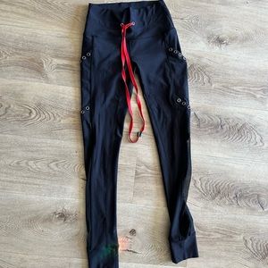 KADYLUXE LEGGINGS WITH GROMMETS AND MESH SIDE CUTOUTS WITH RED TIE XS